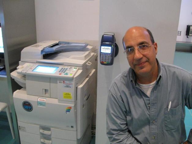 Basil Makhoul with a wall mounted CPI 420 series interfaced to a Ricoh MPC2551 at a Disney resort in Orlando for self service credit card payments of prints, copies and faxes